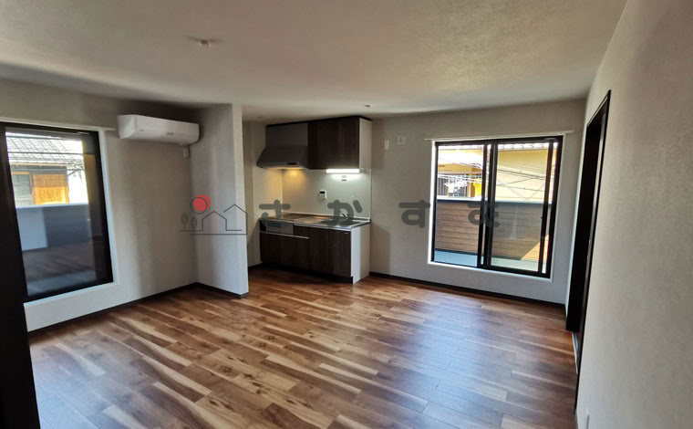 白い壁にダークブラウンの木目フロア。2面バルコニー